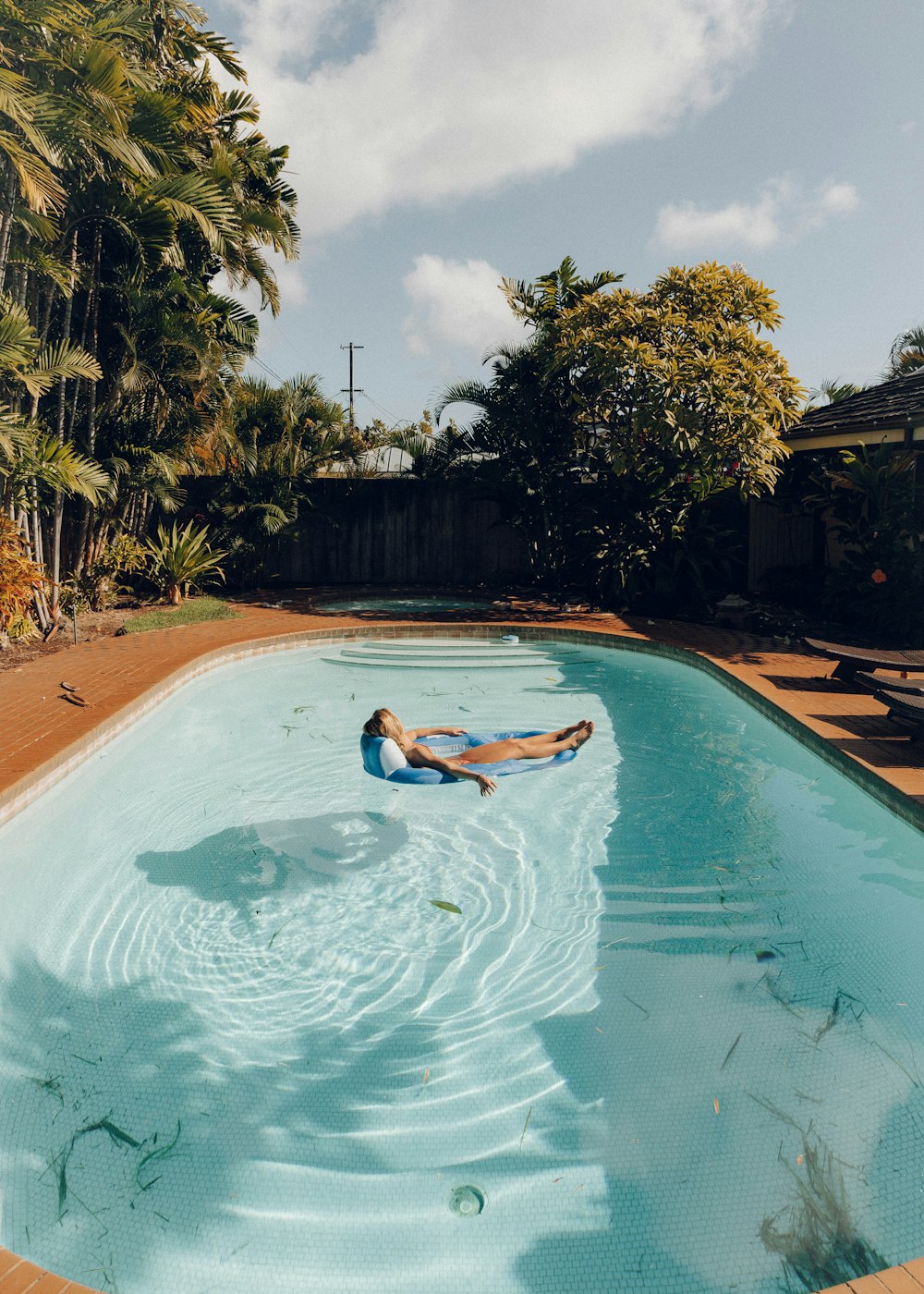 woman in blue bikini swimming on pool during daytime