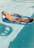 Woman relaxing on a pool float in a clear, blue mineral magnesium pool.