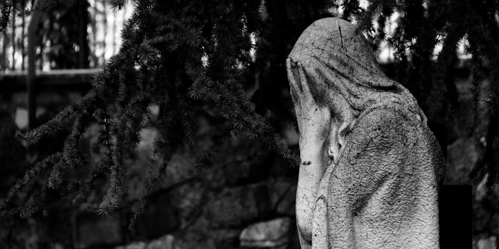 gray concrete statue near green trees during daytime