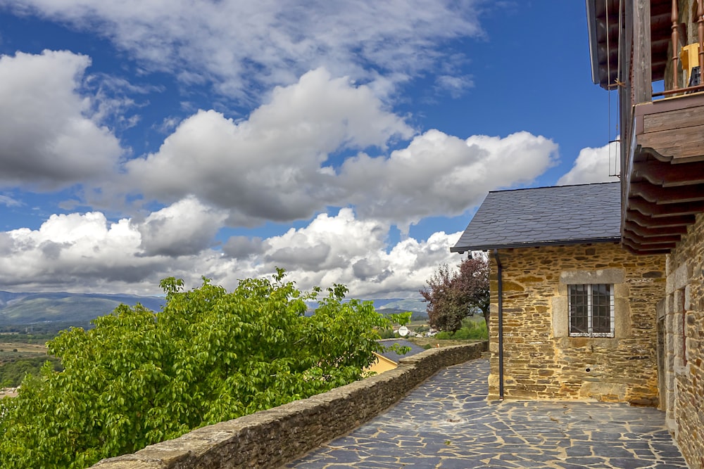 brown brick house under blue sky and white clouds during daytime