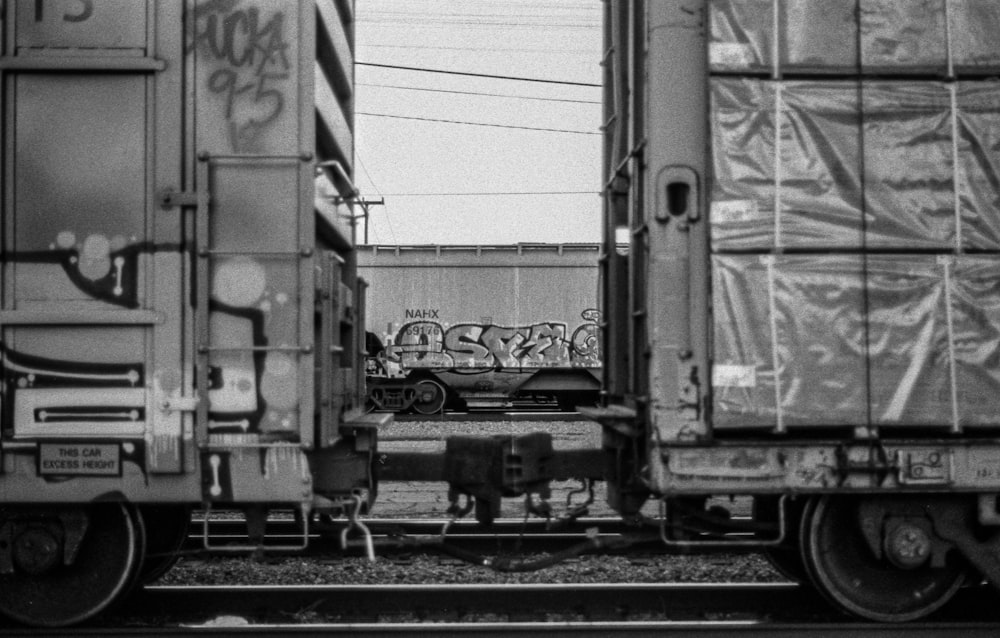 Foto in scala di grigi del treno sui binari ferroviari