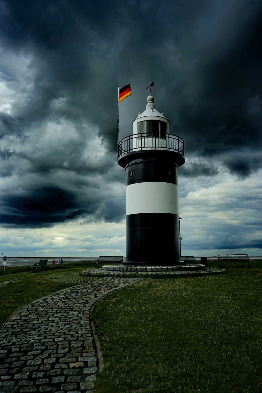 Faro bianco e nero sotto il cielo nuvoloso durante il giorno