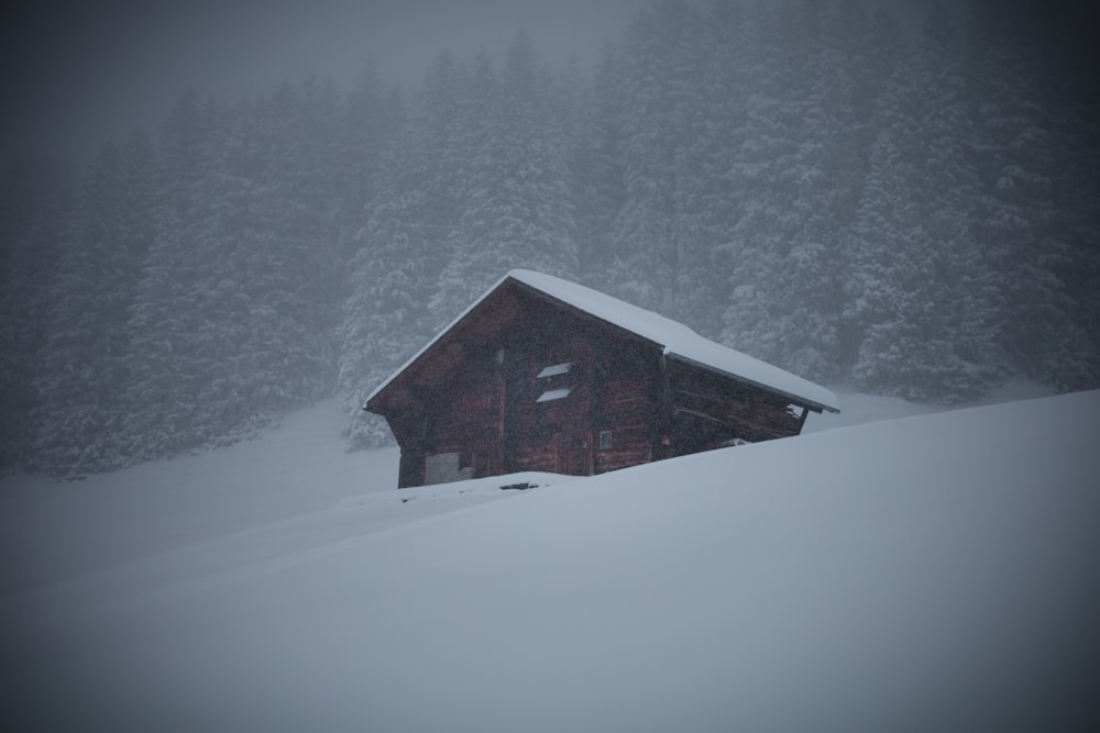 Braunes Holzhaus auf schneebedecktem Boden