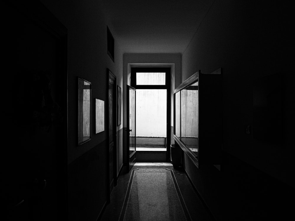 grayscale photo of hallway with glass windows