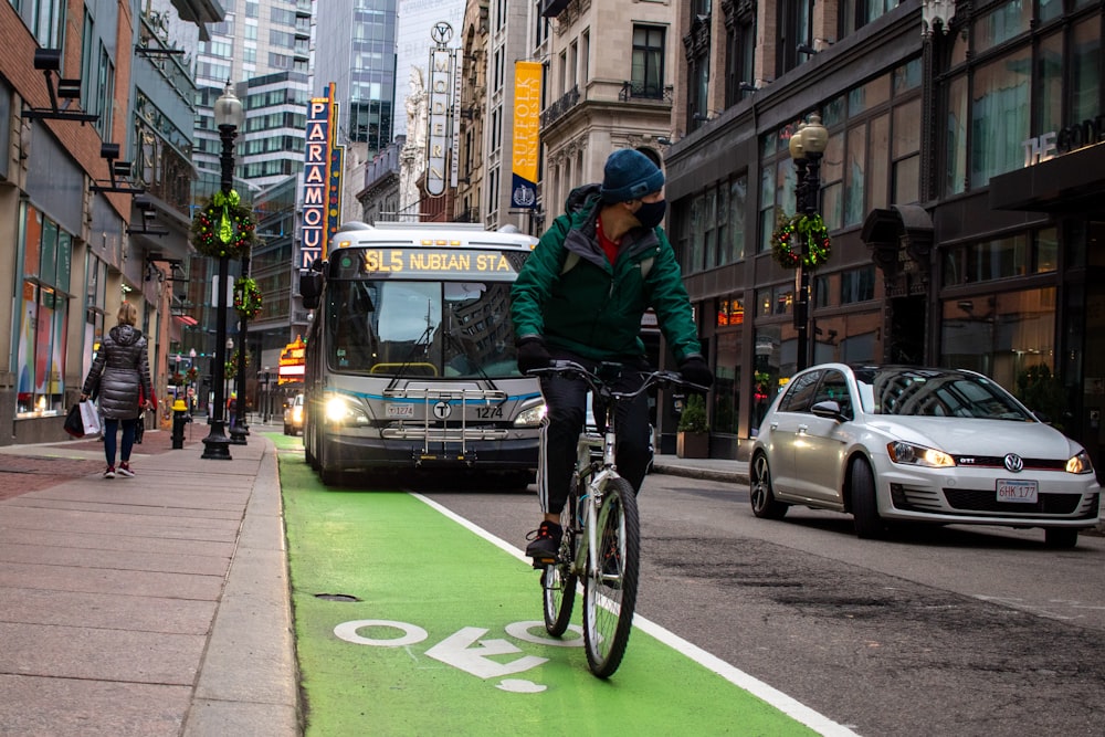 man in black jacket riding bicycle on road during daytime