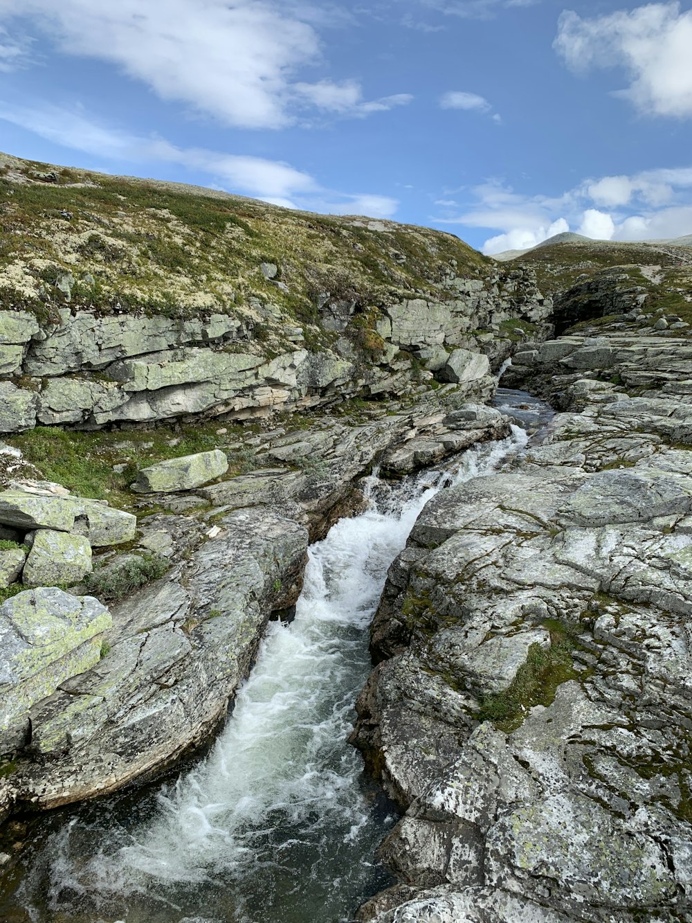 river between rocky mountains under blue sky during daytime