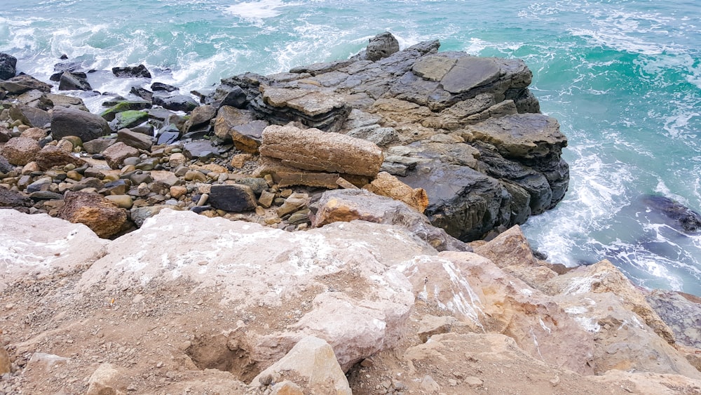 brown rocks near body of water during daytime