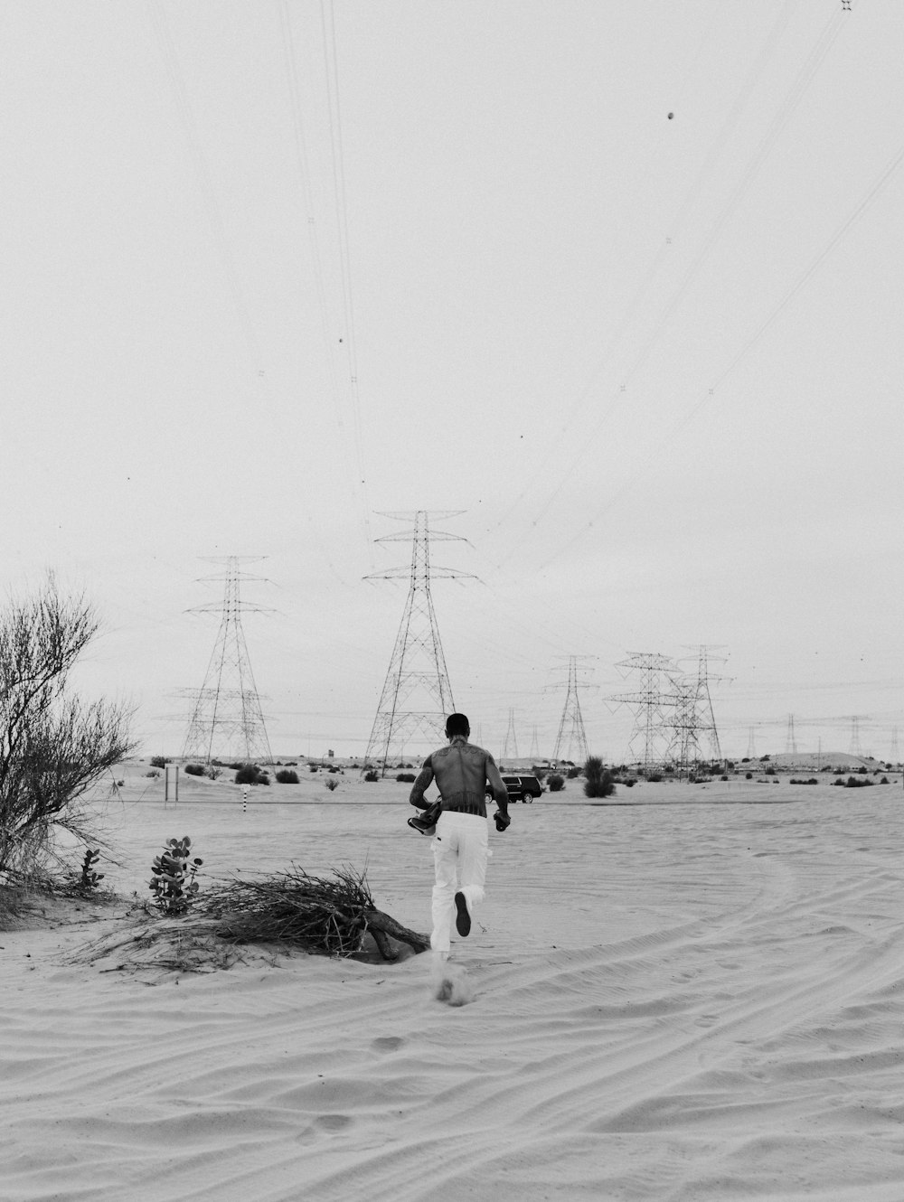 grayscale photo of man and woman walking on snow covered ground