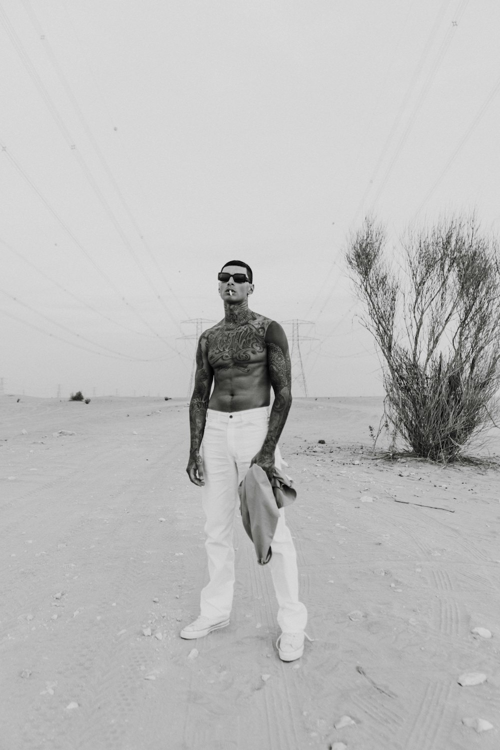 topless man in white pants walking on snow covered ground during daytime