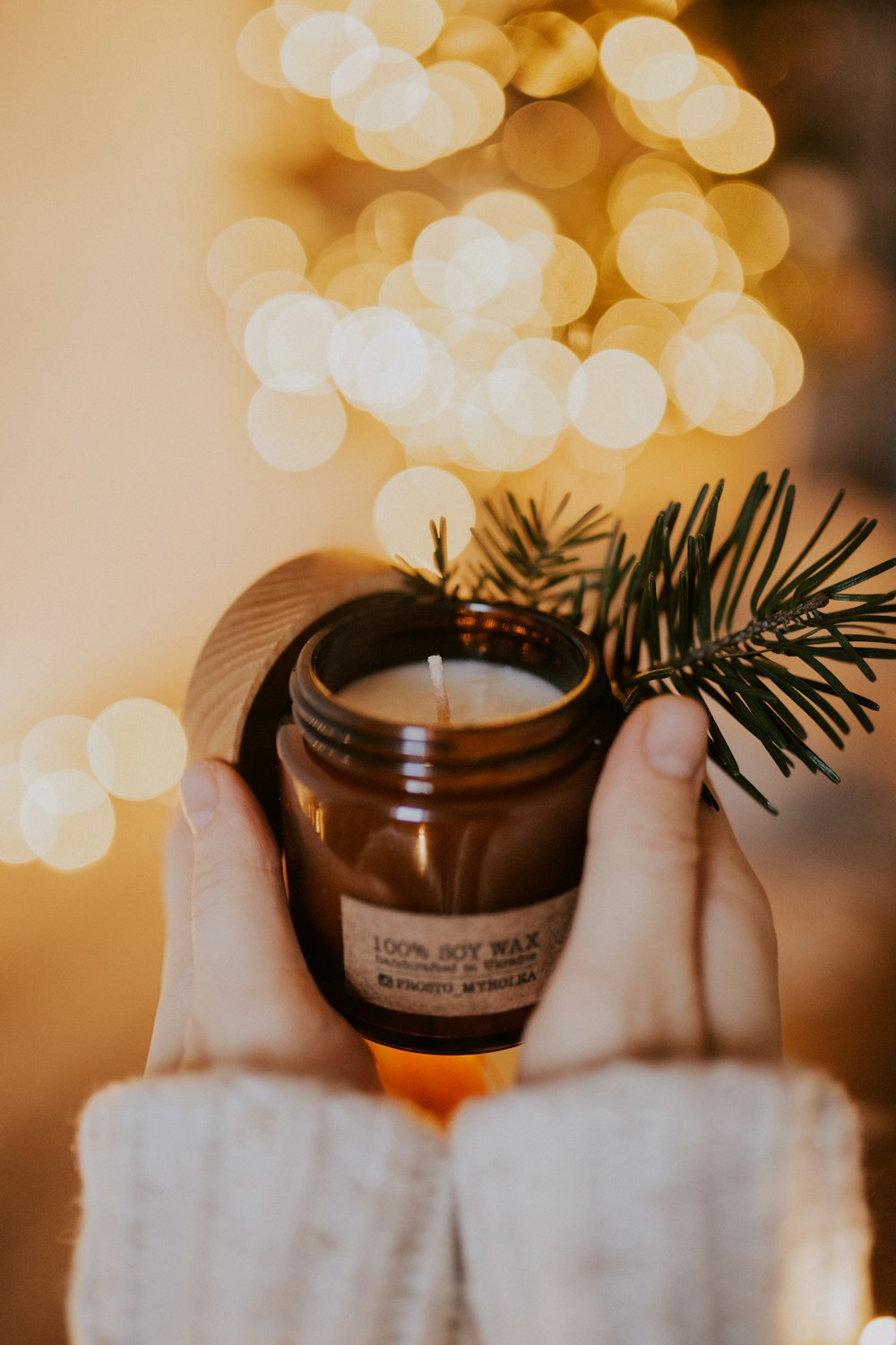 person holding brown glass jar