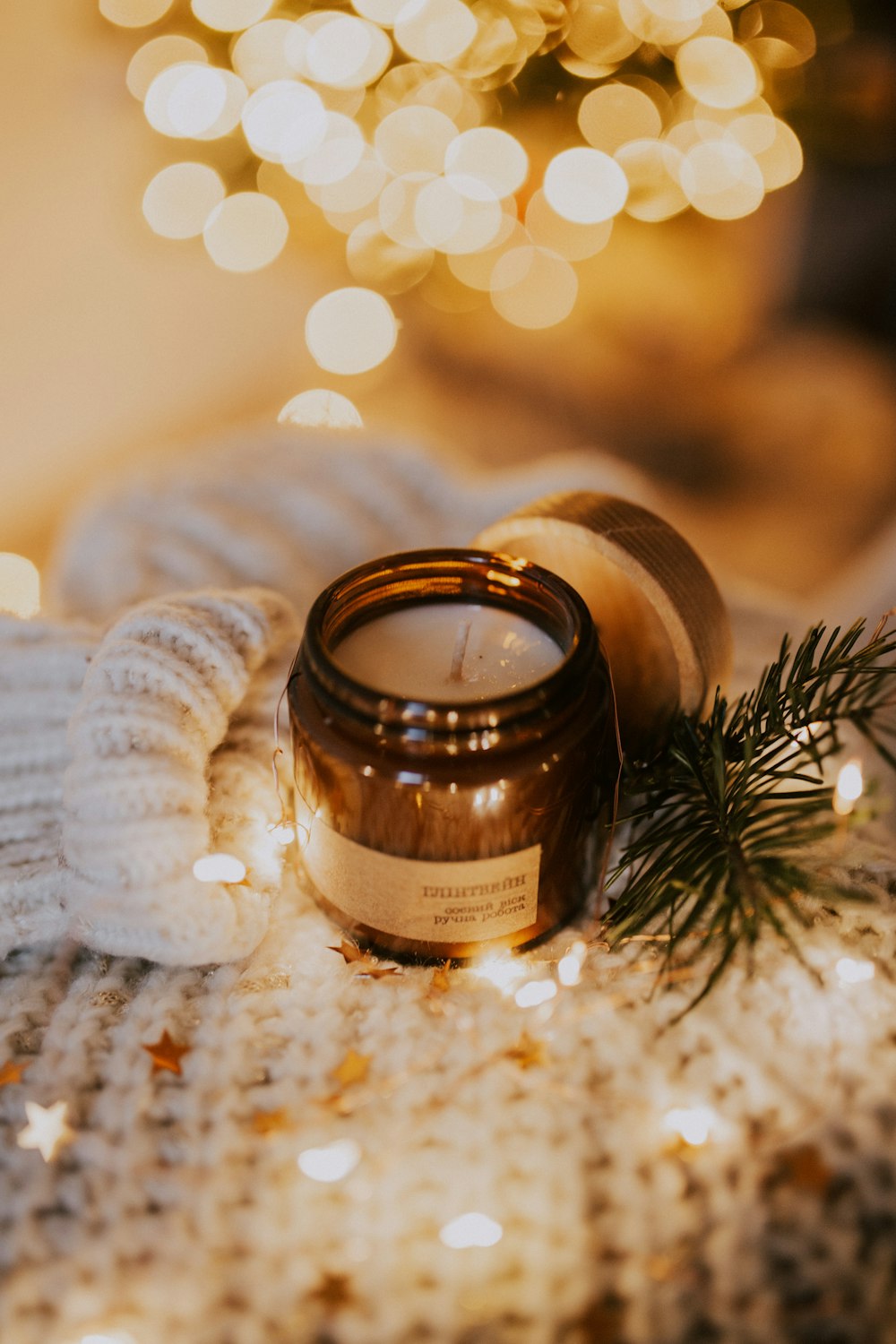 brown round candle on white knit textile