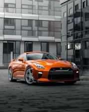 orange porsche 911 parked near building