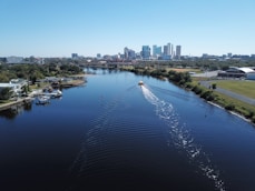white boat on body of water near city buildings during daytime