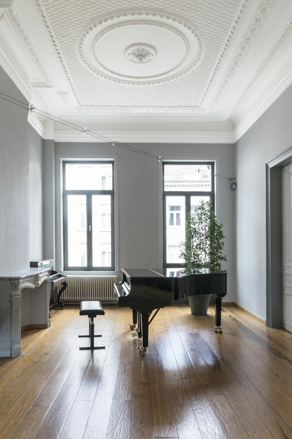 black grand piano near window