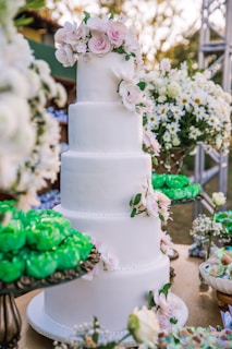 white 3 tier cake with green and pink flower accent