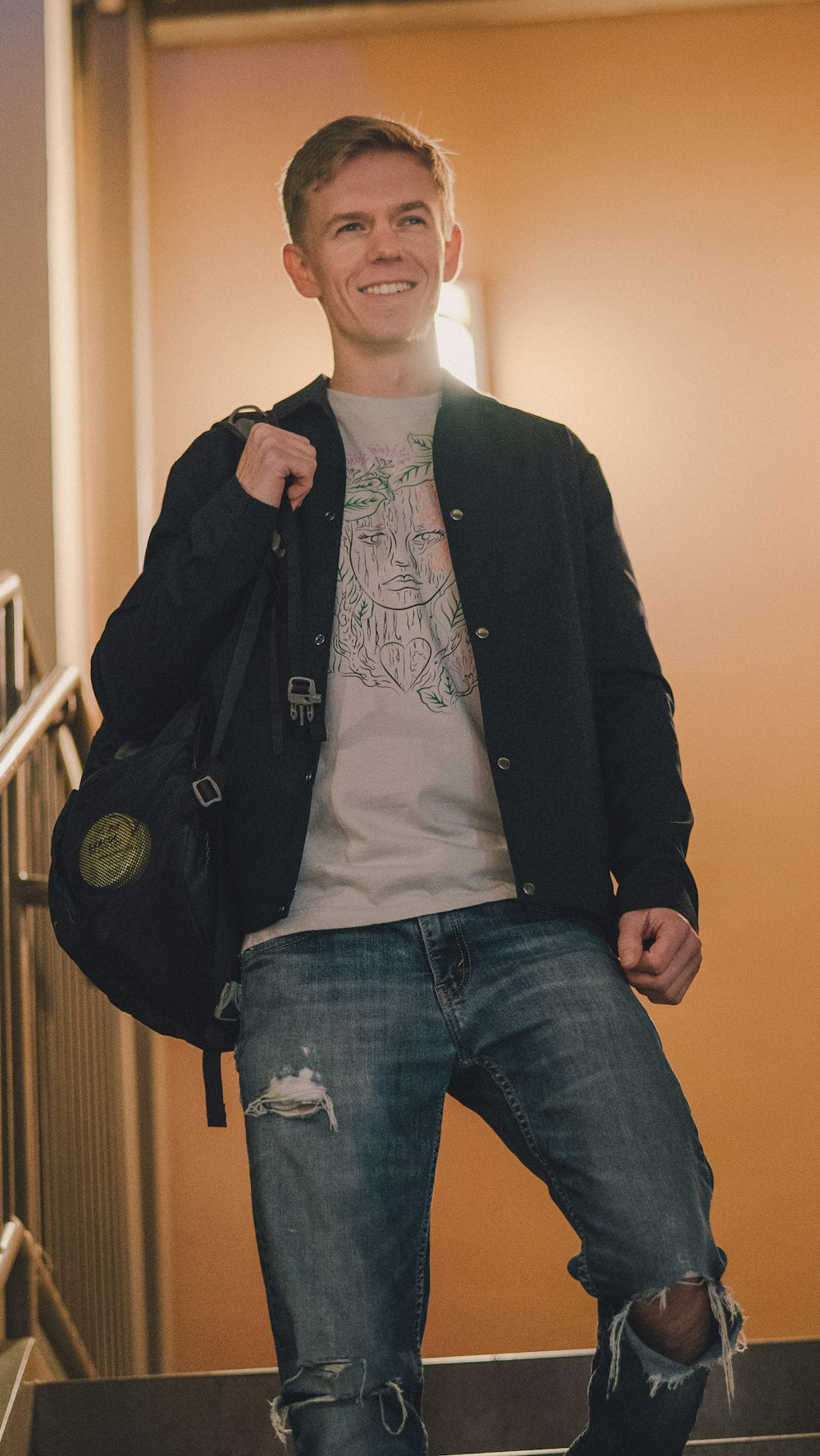 man in black button up jacket and blue denim jeans