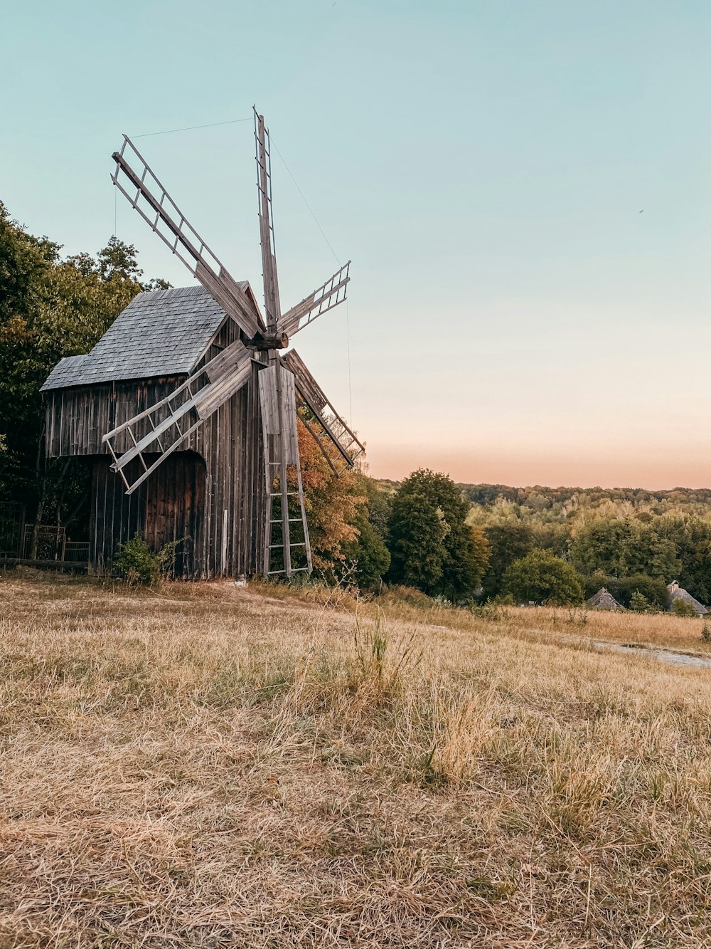 maison en bois brun sur un champ d’herbe brune pendant la journée