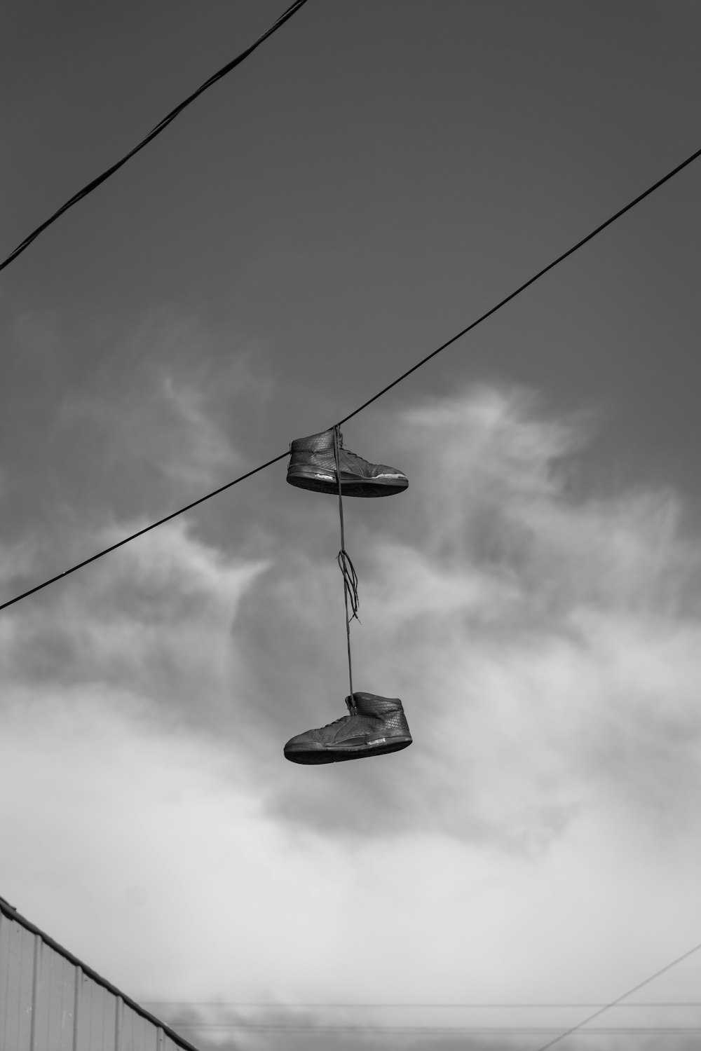 Photo en niveaux de gris d’un lampadaire sous un ciel nuageux