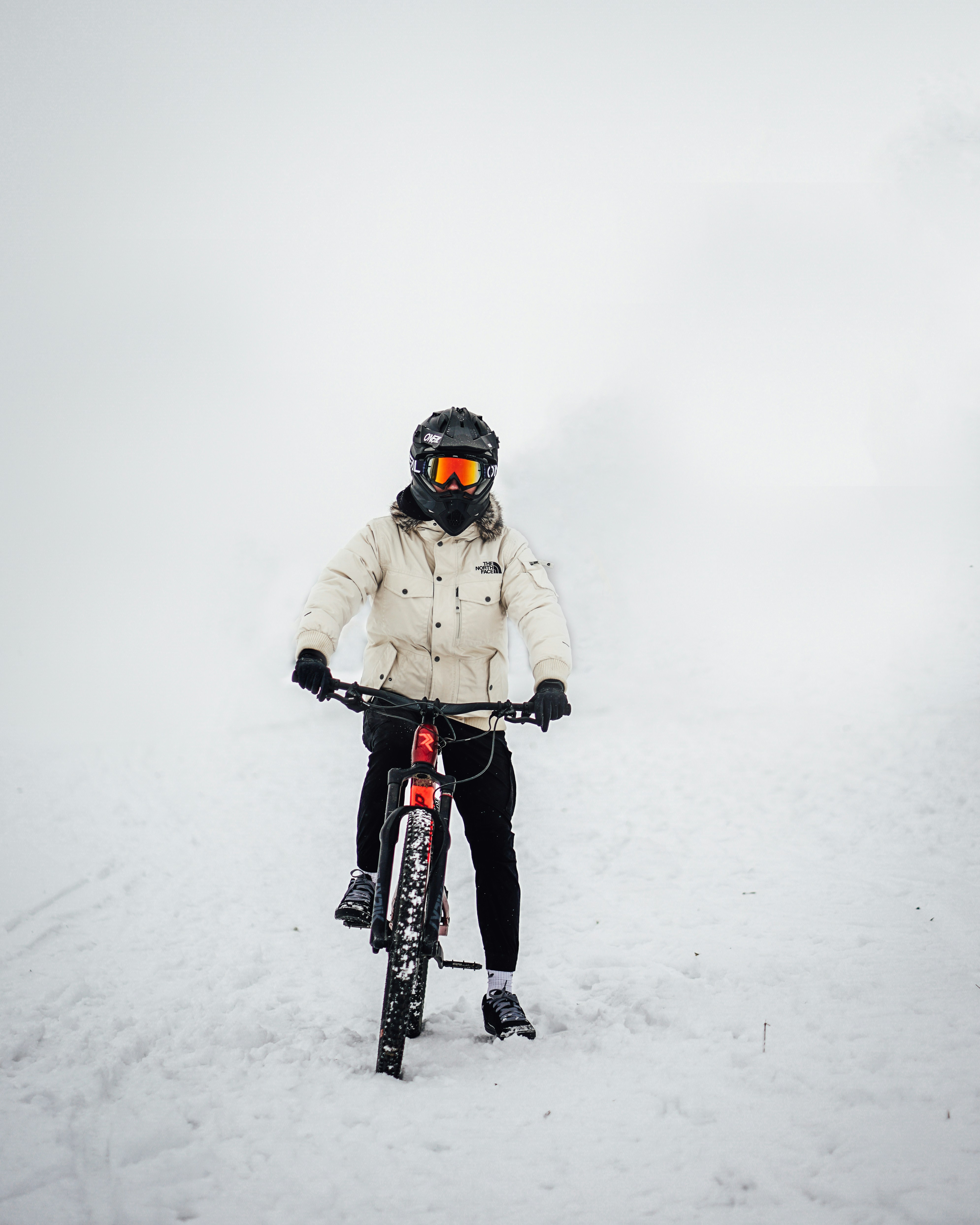 Man in black jacket riding on black and red bicycle