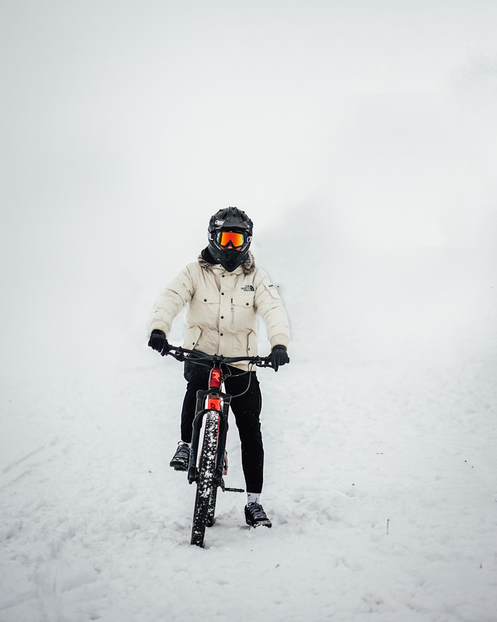 man in black jacket riding on black and red bicycle