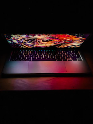 A sleek laptop screen showing a complex AI algorithm visualization in bright colors