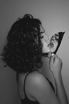 A figurative painting showing a person embracing their reflection in a cracked mirror, symbolizing self-acceptance.