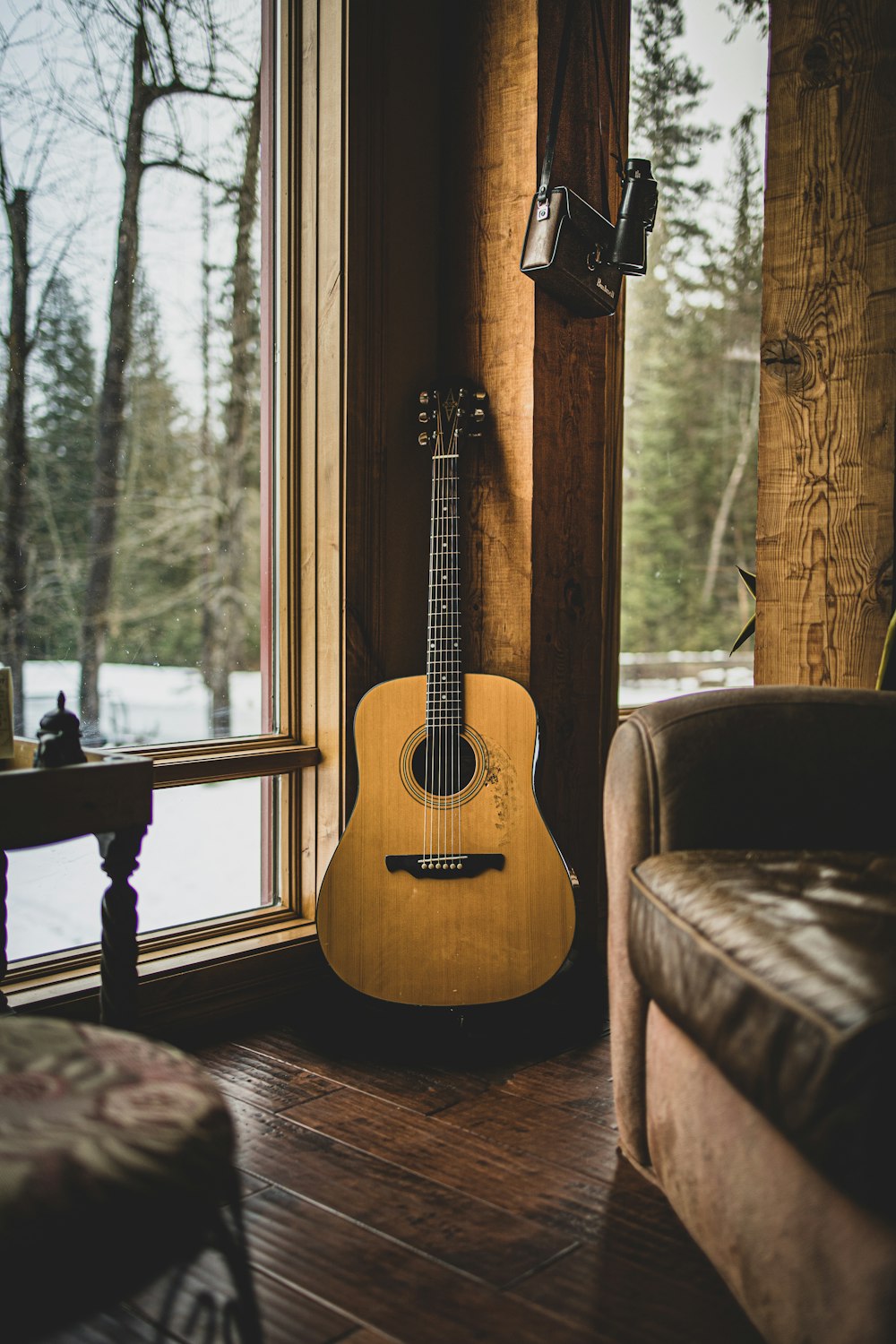 brown acoustic guitar on brown wooden chair