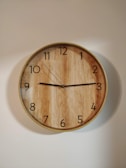 brown wooden round wall clock at 10 00