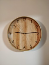 brown wooden round wall clock at 10 00