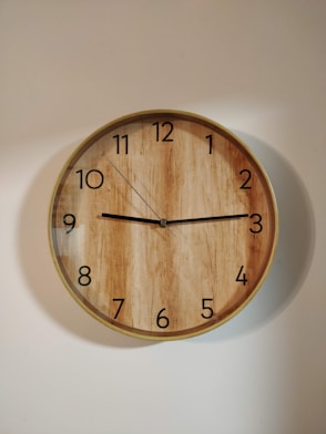 brown wooden round wall clock at 10 00