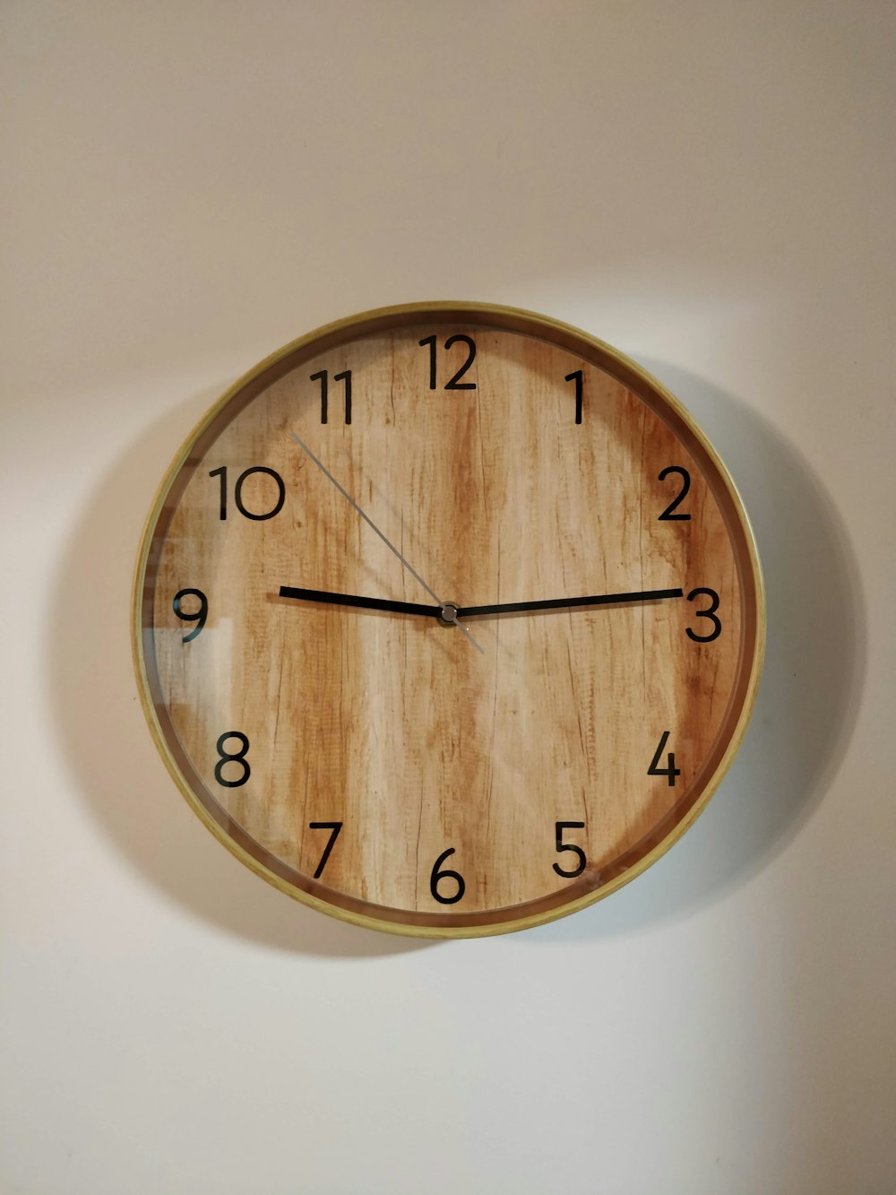 horloge murale ronde en bois marron à 10h00