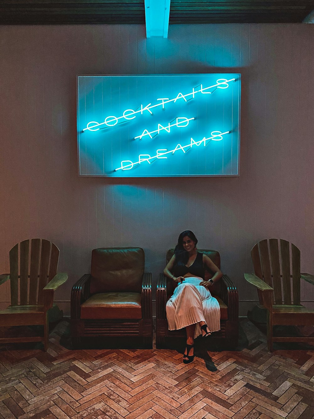 woman in white dress sitting on black leather armchair