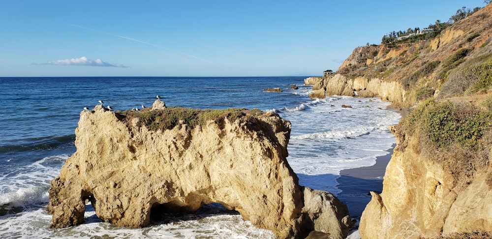 brown rock formation near sea during daytime