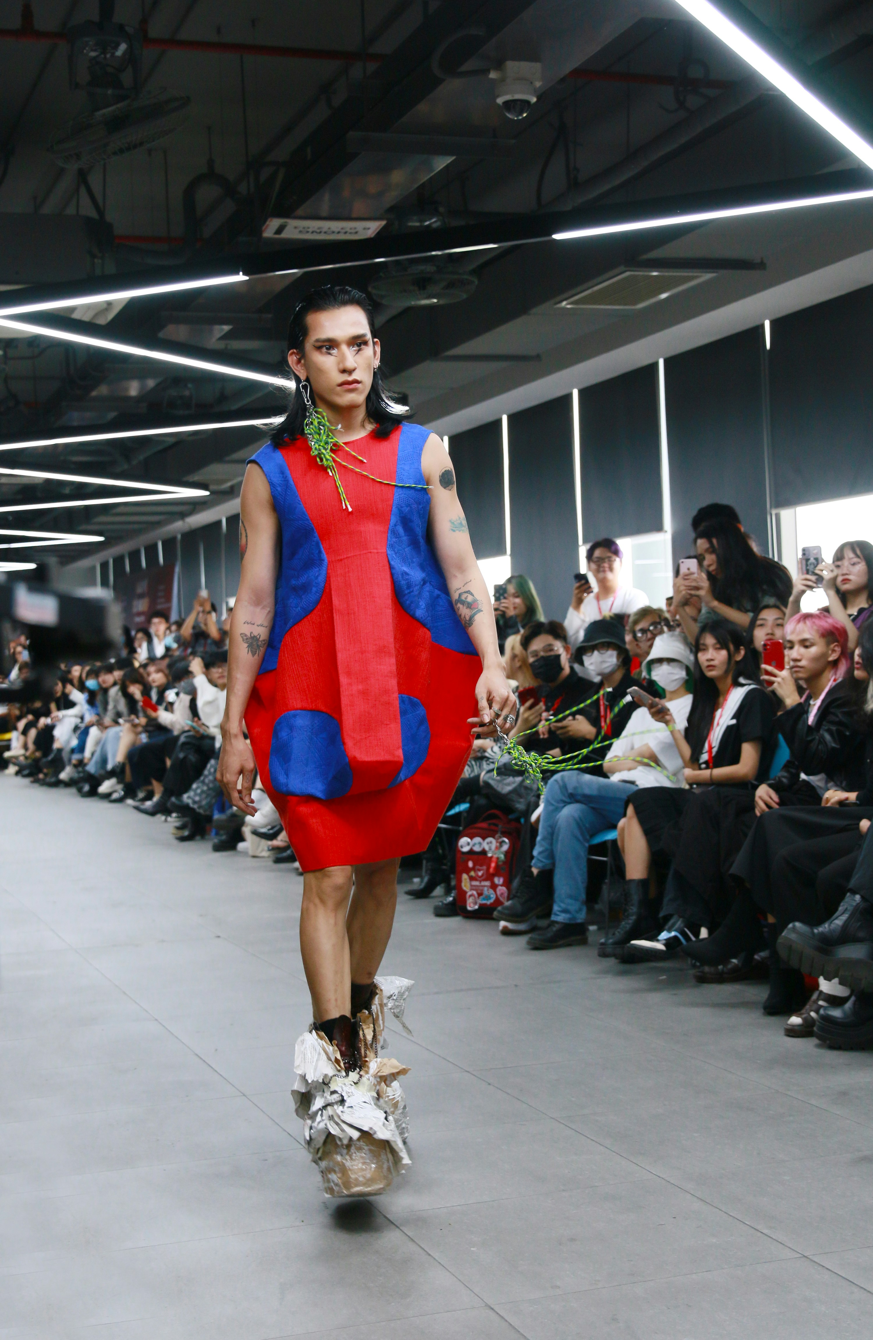 Model wearing gender-neutral fashion with bold colors and avant-garde styling