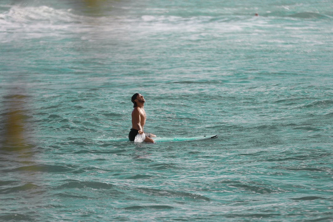 woman in black bikini surfing on sea during daytime