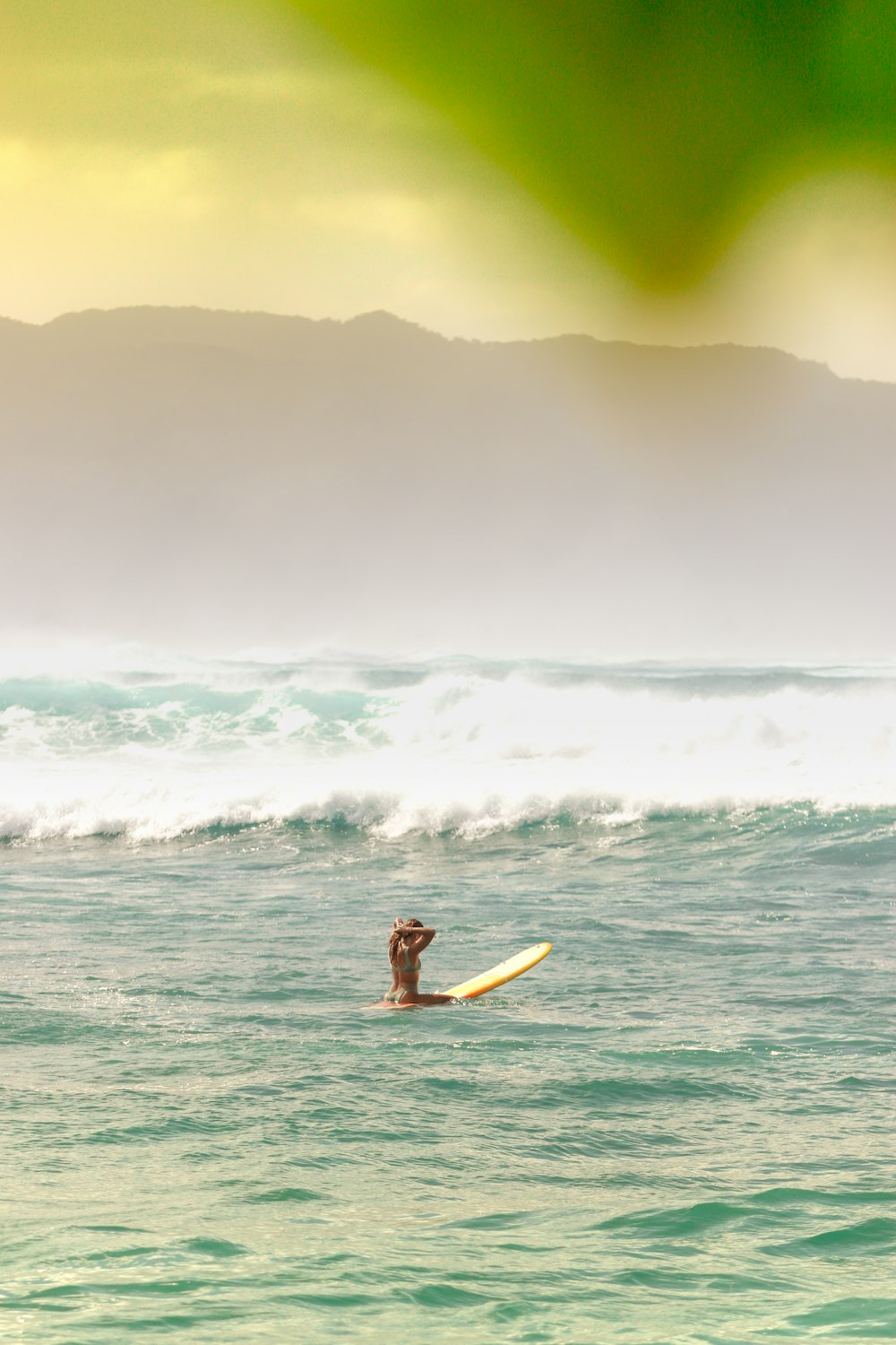 woman in black bikini surfing on sea waves during daytime