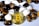 A gold-colored Bitcoin coin is surrounded by polished stones. The stones are a mix of white and tiger's eye gemstones, which have a rich brown and yellow hue.
