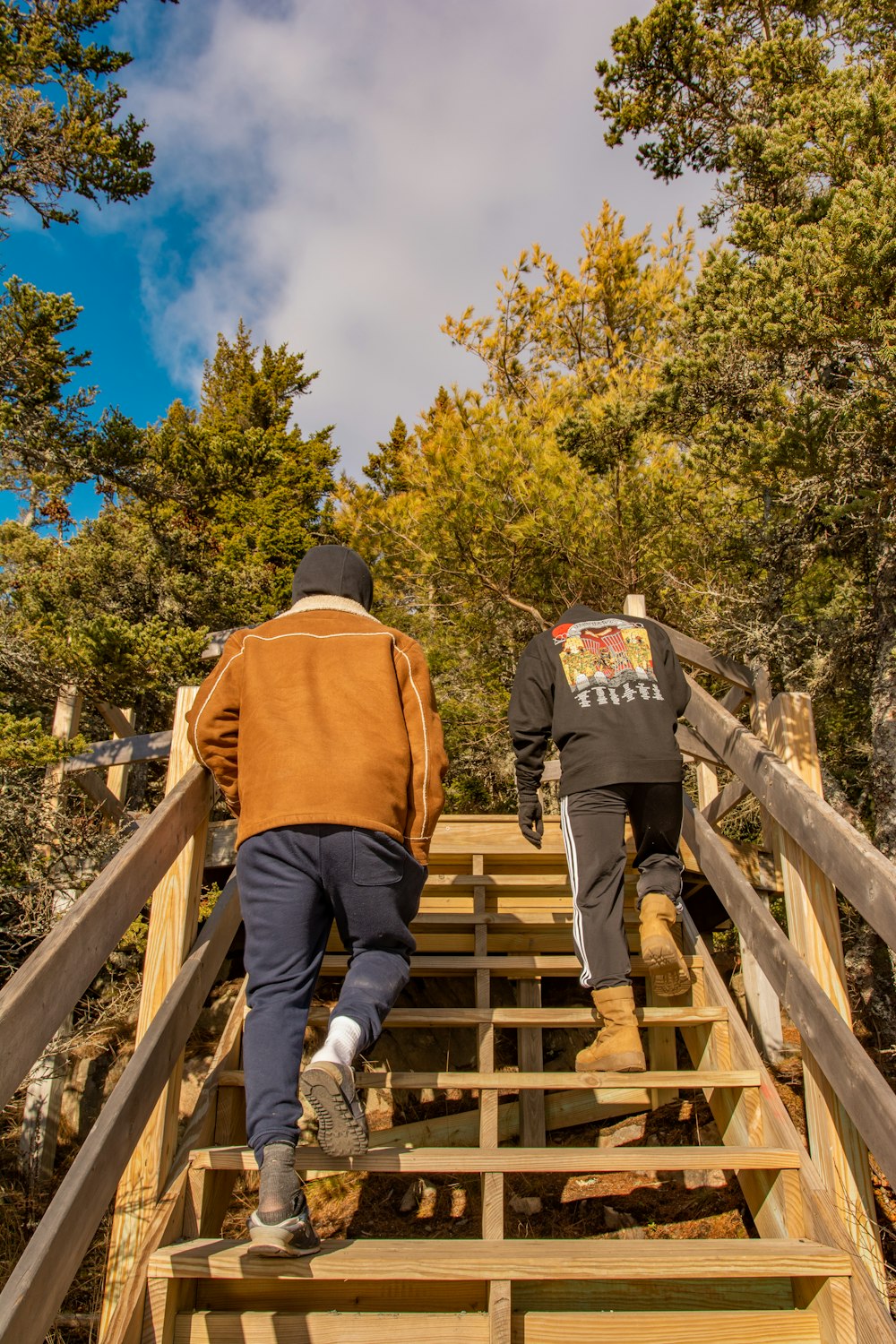 Homme en veste marron et pantalon noir marchant sur un pont en bois