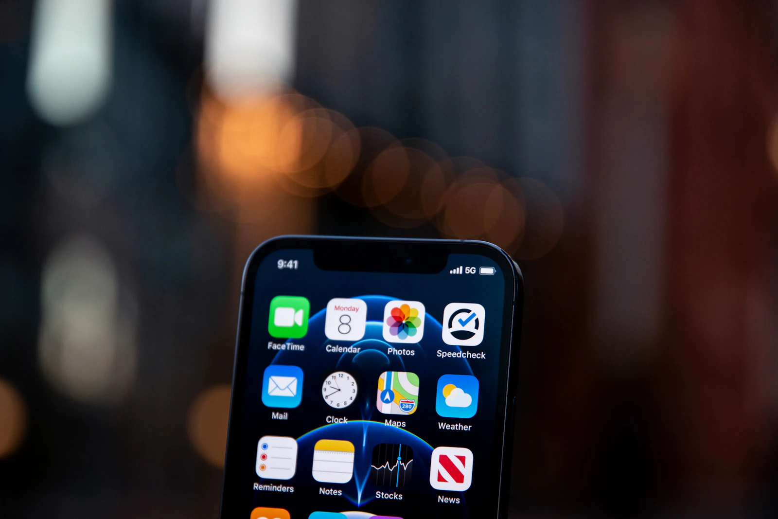 A person holding a phone with apps on the screen.