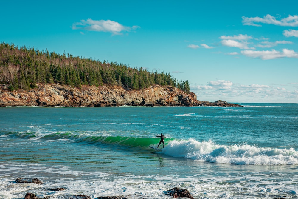 person surfing on sea waves during daytime