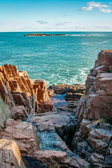 brown rock formation near body of water during daytime
