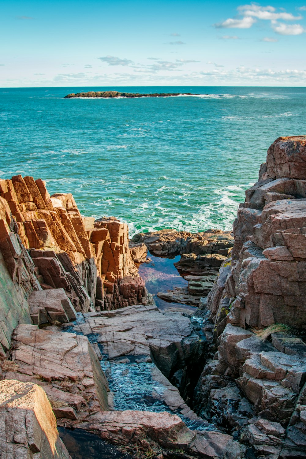 brown rock formation near body of water during daytime