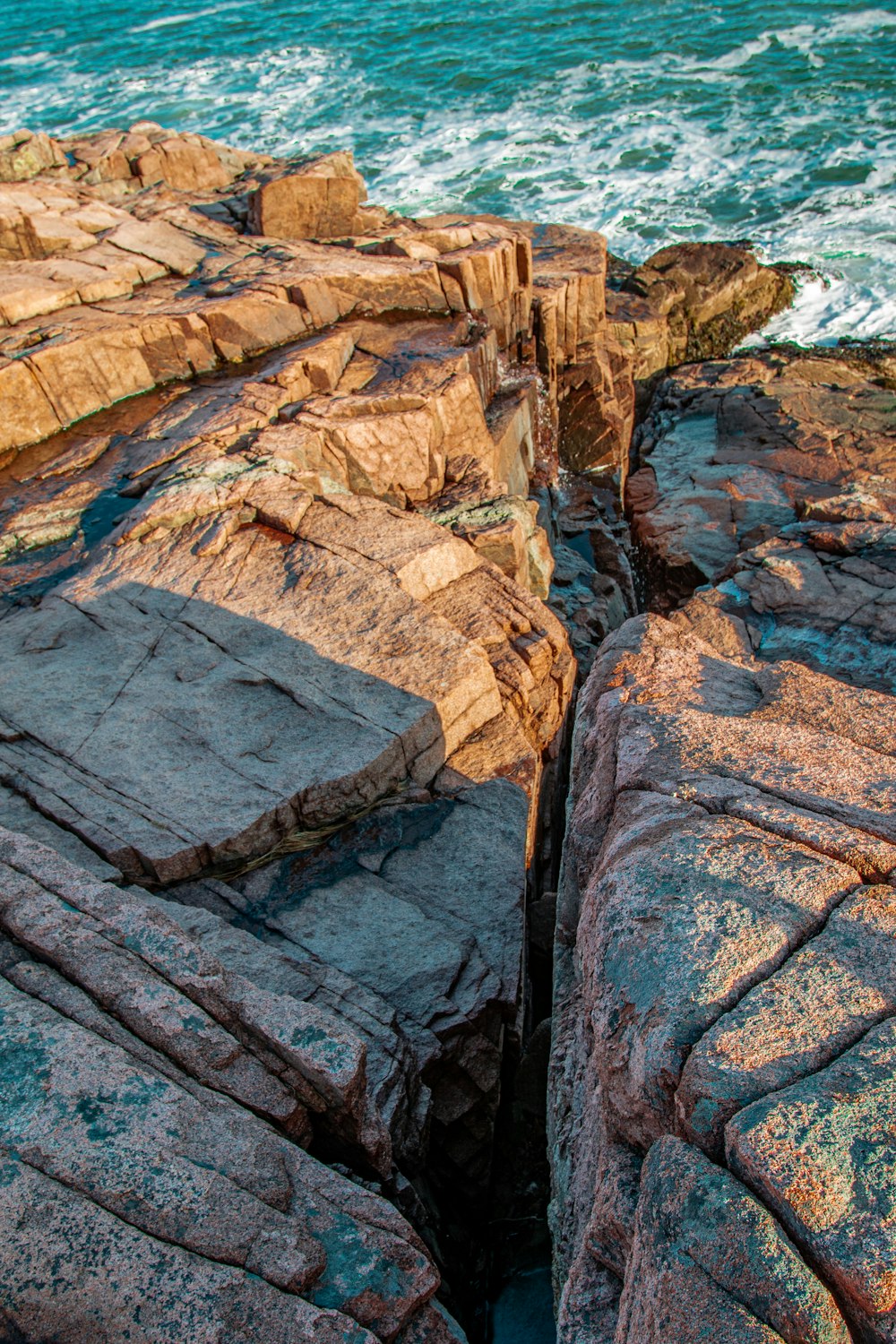 brown rock formation near body of water during daytime