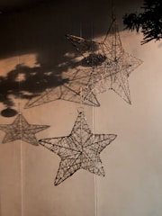An elegant laser-cut star map hanging on a wall, illuminated by soft light.