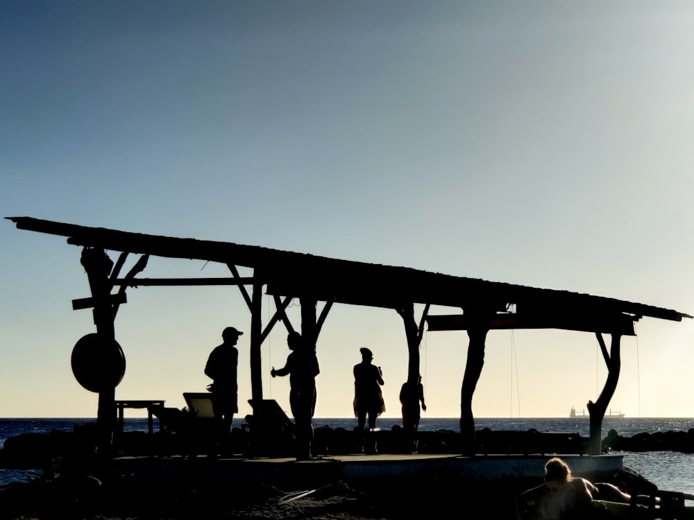 silhouette of people standing on bridge during daytime