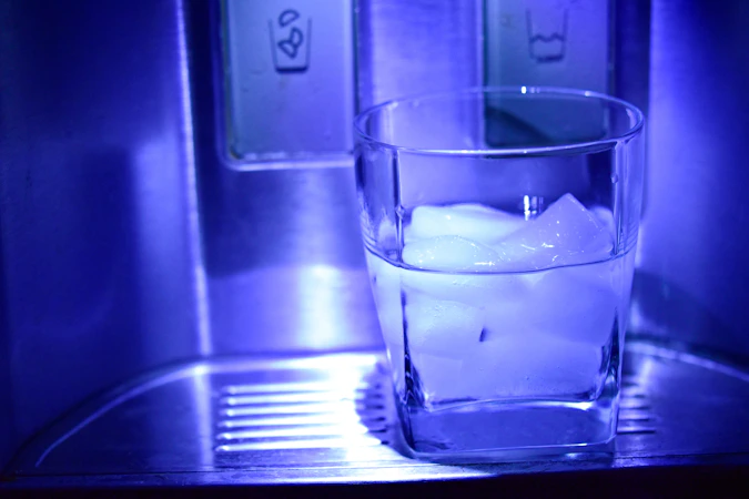 Glass of filtered water from refrigerator dispenser - filter replacement