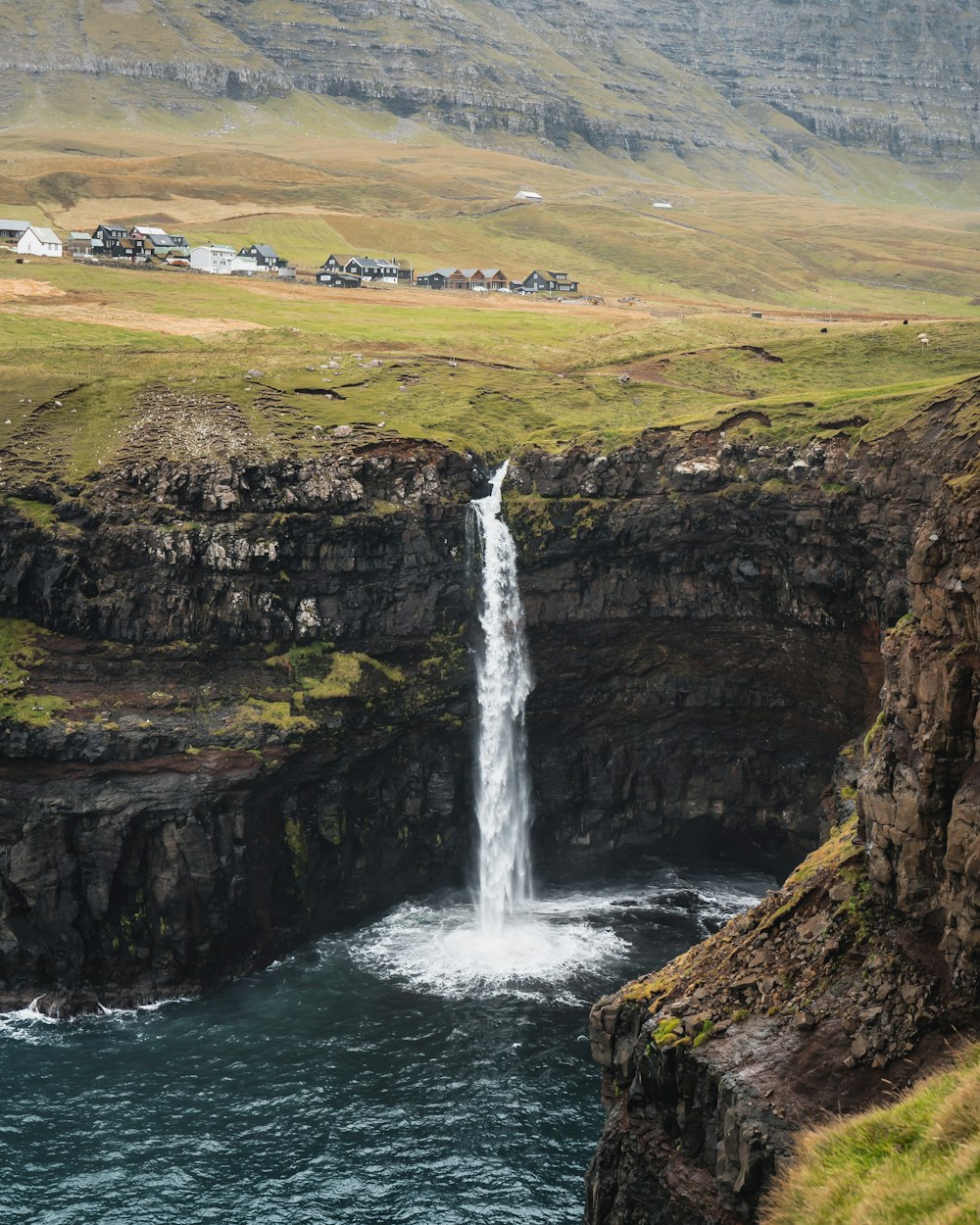 waterfalls on brown rocky mountain during daytime