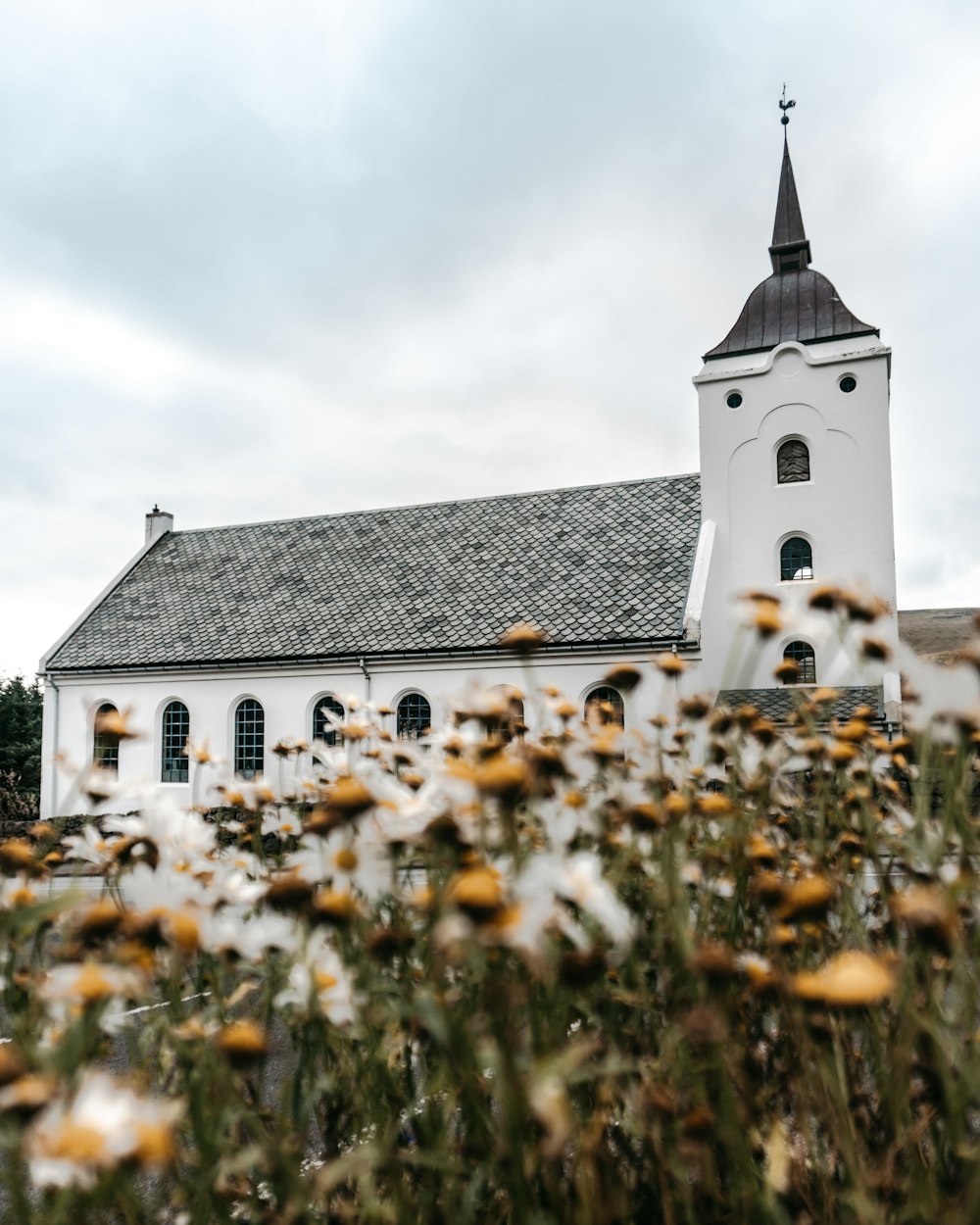 white and brown church under white clouds during daytime