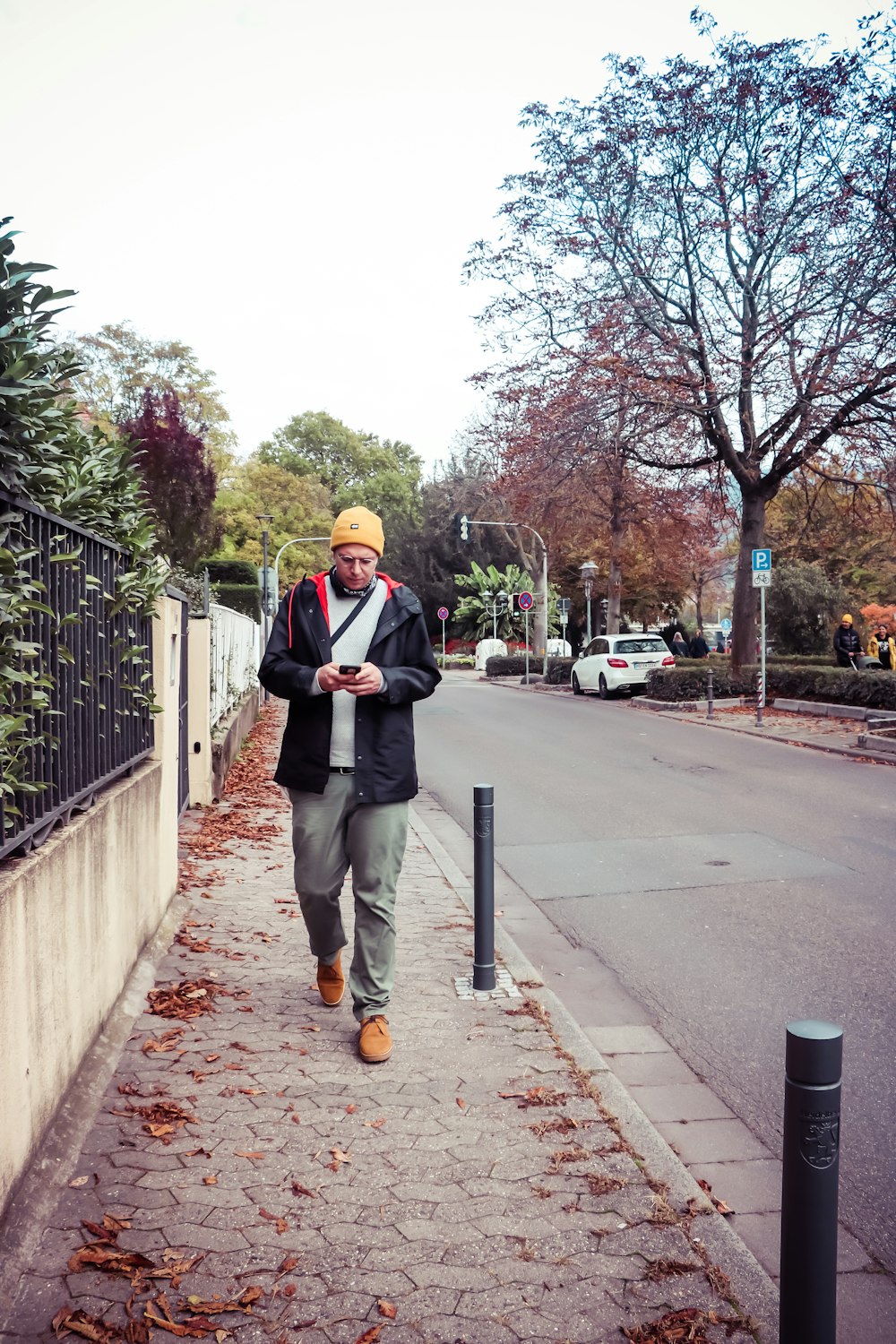 homme en costume noir debout sur le trottoir pendant la journée