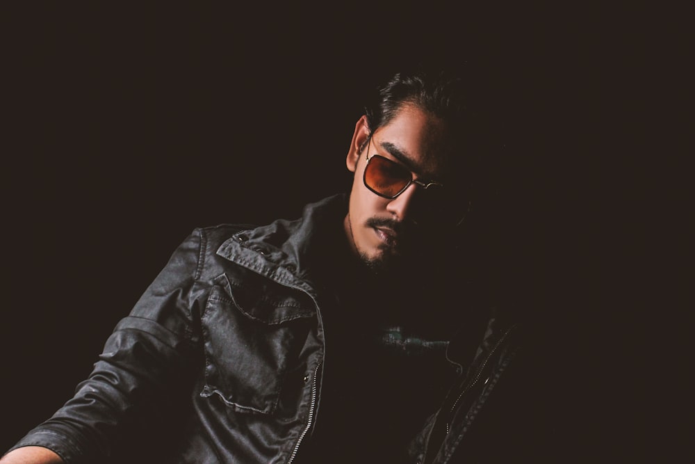man in black leather jacket wearing black sunglasses